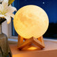 Rechargeable Moon Night Light with Touch Control illuminating a cozy room with a wooden stand and flowers.
