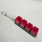 Clickie Keychain with vibrant red tops and black base, perfect for organizing keys stylishly.