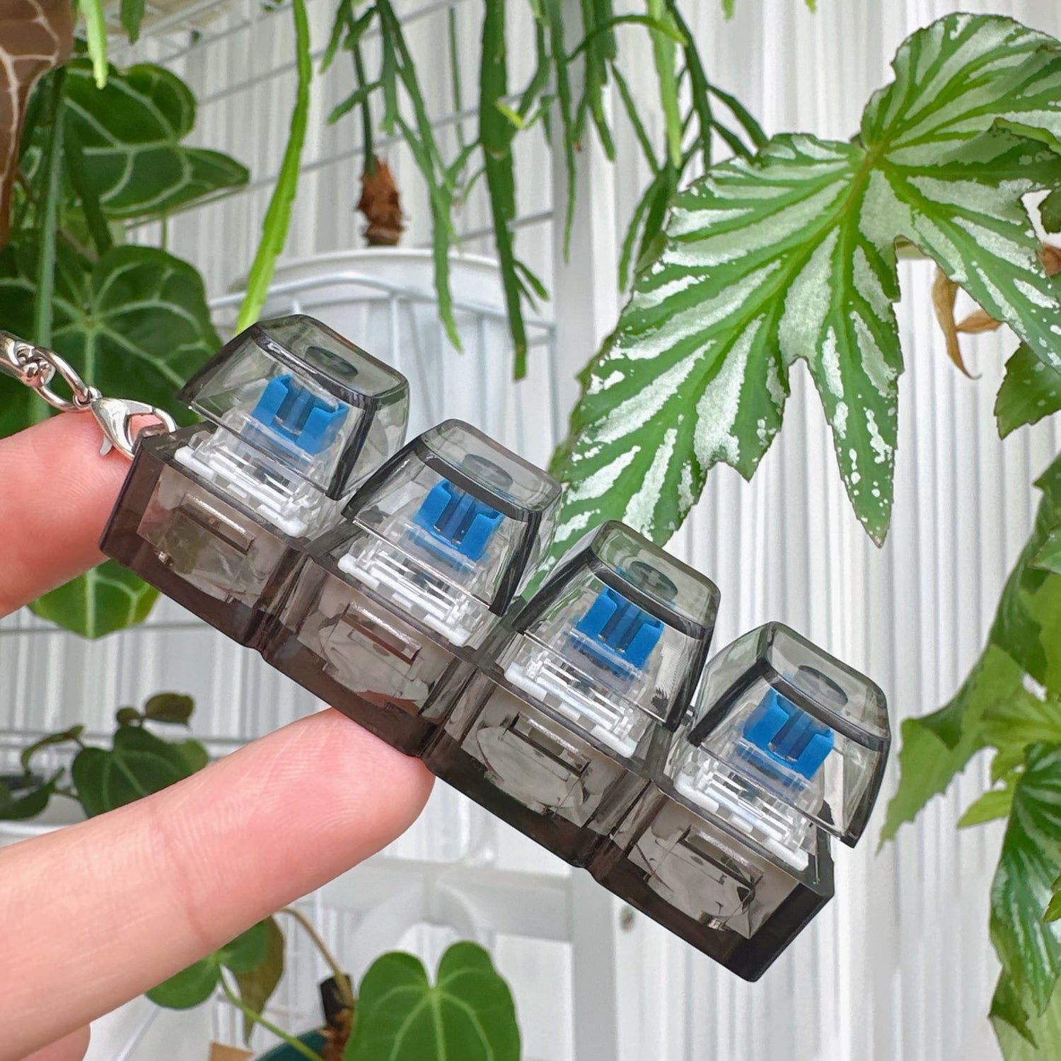 Clickie Keychain holding 4 pronged key compartments in a stylish design among greenery.