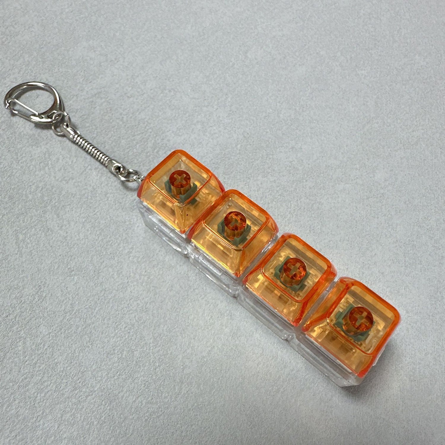 Clickie Keychain featuring four orange cubic designs for key organization and style.