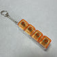 Clickie Keychain featuring four orange cubic designs for key organization and style.