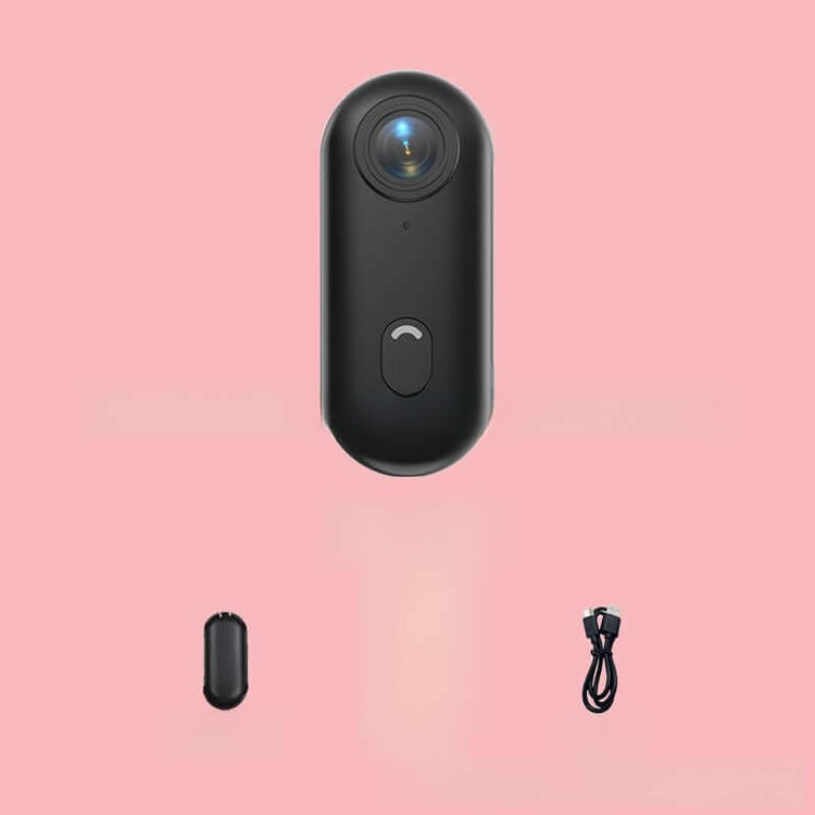4K Thumb Camera – Ultra Compact in black with charging cable on a pink background.