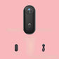 4K Thumb Camera – Ultra Compact in black with charging cable on a pink background.